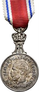 Haakon VII. St.Olavsmedaljen. Miniatyr. Rui. Sølv med krone og bånd. 15 mm