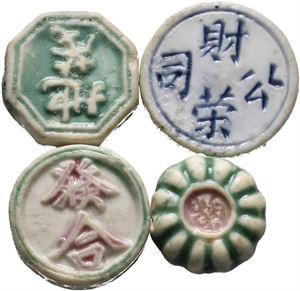 Four porcelain tokens/coins