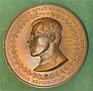 Fridtjof Nansen. Belønningsmedalje fra Royal Geographical Society 1896. Wyon. Bronse. 70 mm. RR. Ex. Oslo Mynthandel a/s nr.49 27/4-2002 nr.314. Denne medaljen er utdelt i 14 eksemplarer. 1 i gull (Nansen), 5 i sølv og 8 i bronse. Dette eksemplaret er tildelt Adolf Juell som var kokk på Fram. Se artikkel i Oslo Mynthandel a/s auksjonskatalog nr. 49 s.17-18.