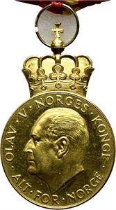 Olav V. Kongens fortjenstmedalje. Hansen. Gull med hempe og bånd. 28 mm