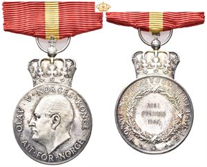 Olav V. Kongens fortjenstmedalje. Hansen. Sølv. 28 mm med krone og bånd